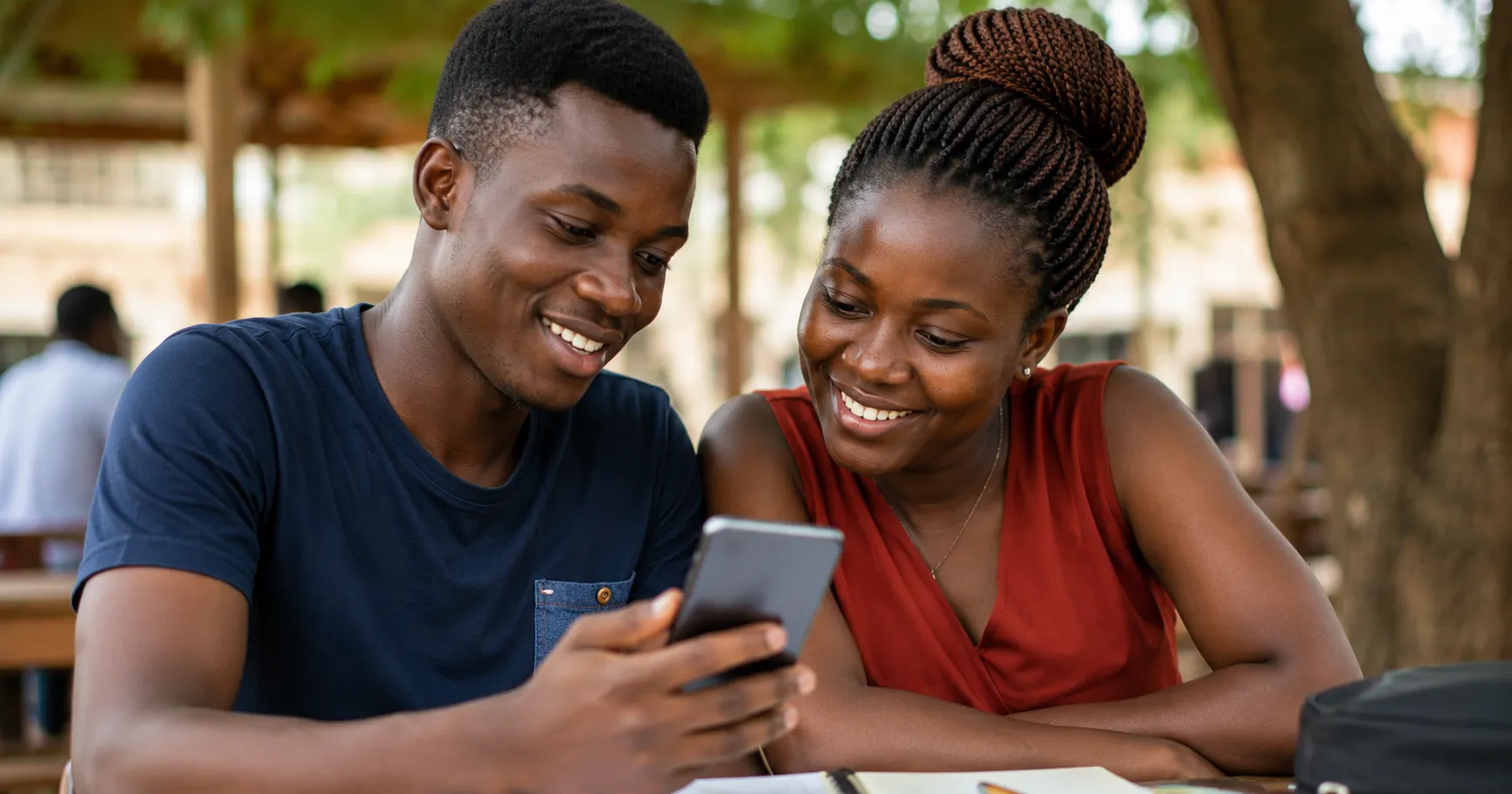 Two young Ghanaians sharing AI tips together on a smartphone